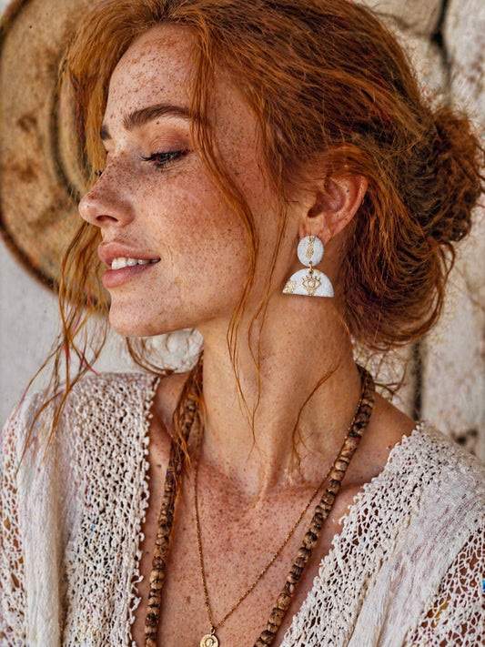 Boucles d’oreilles blanches et dorées légères Lumière divine de Les Trésors de Cia, montrant les détails délicats et élégants.