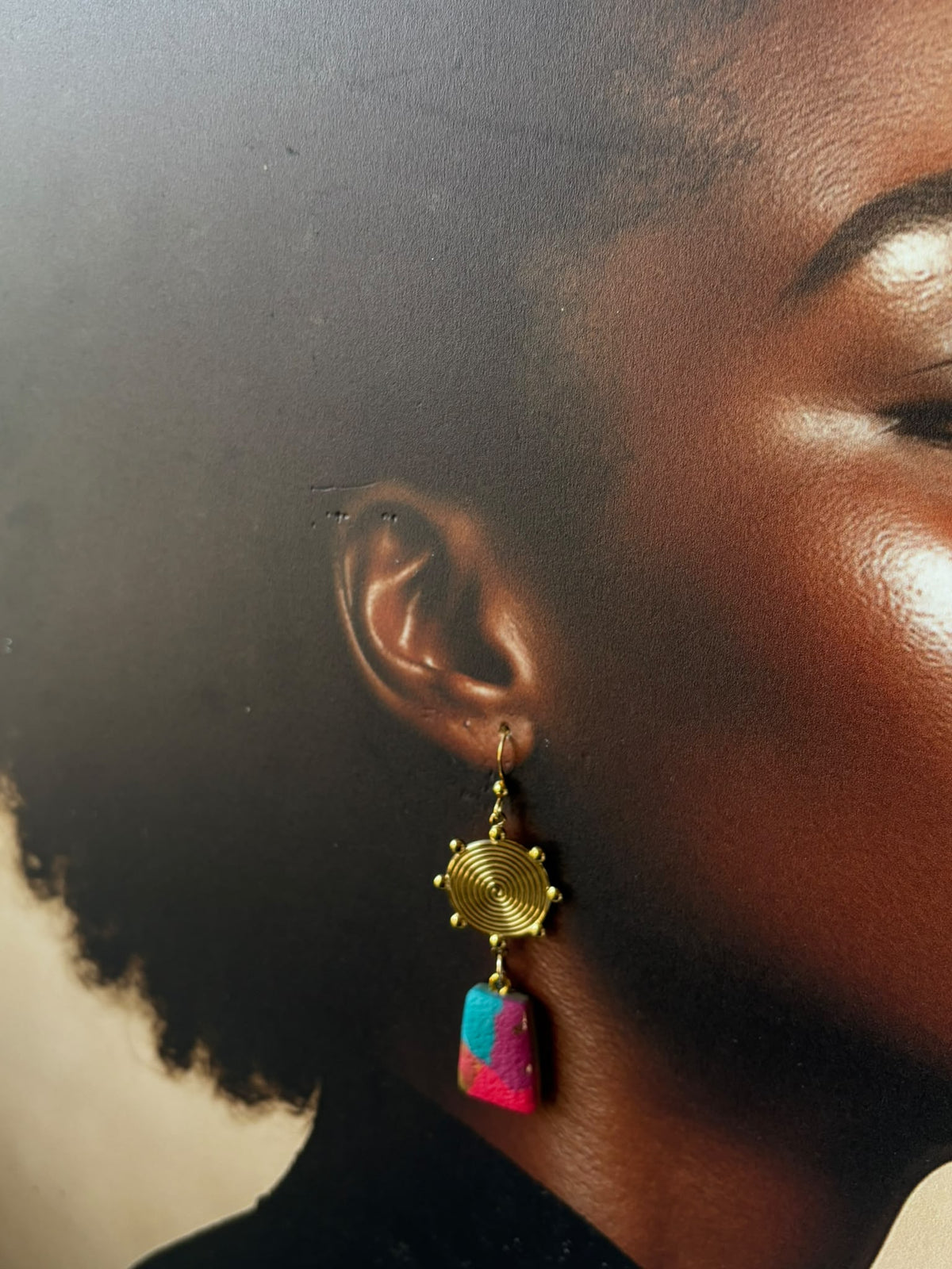 Boucle d'oreille portée à crochet : médaillon spirale doré et petit trapèze d'argile fuchsia et turquoise