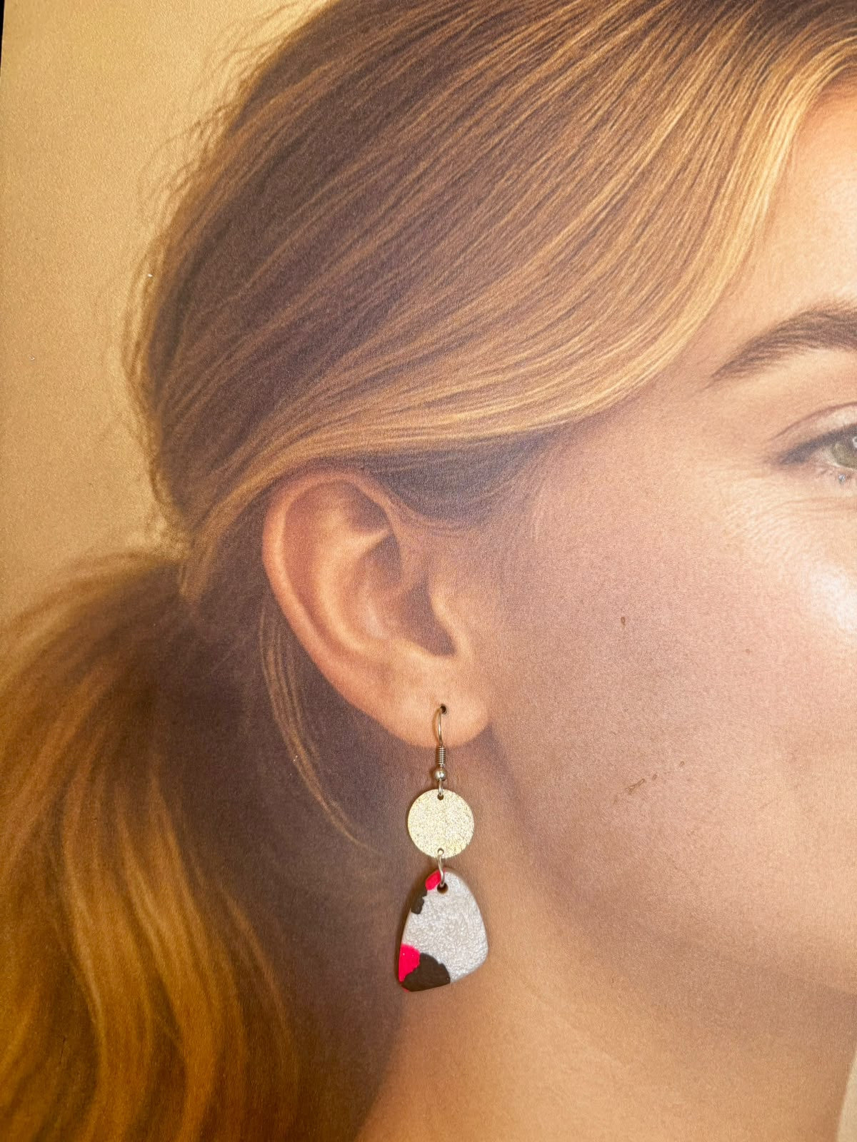 Boucles d'oreilles à crochet doré, petit disque pailleté doré et pendant triangle aux angles arrondis en argile polymère gris argenté traversée de rose fluo et de noir