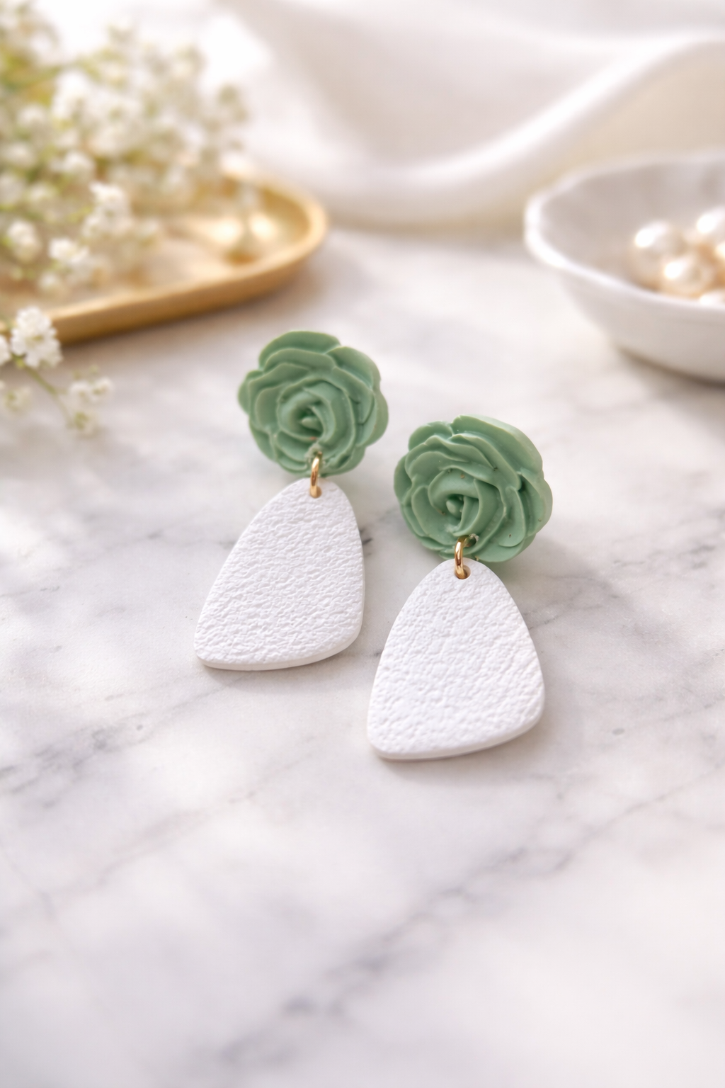Boucles d’oreilles légères fleuries vert d’eau de la marque Les Trésors de Cia, avec détails floraux délicats.