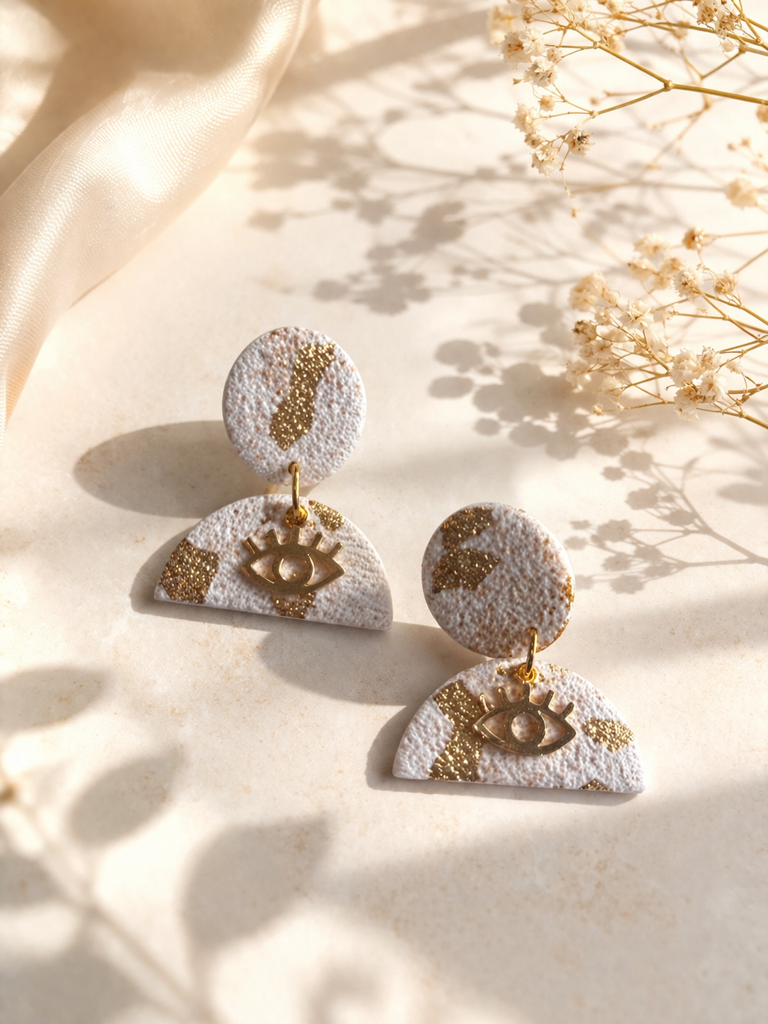 Boucles d’oreilles blanches et dorées légères Lumière divine Les Trésors de Cia, visibles avec détails élégants.