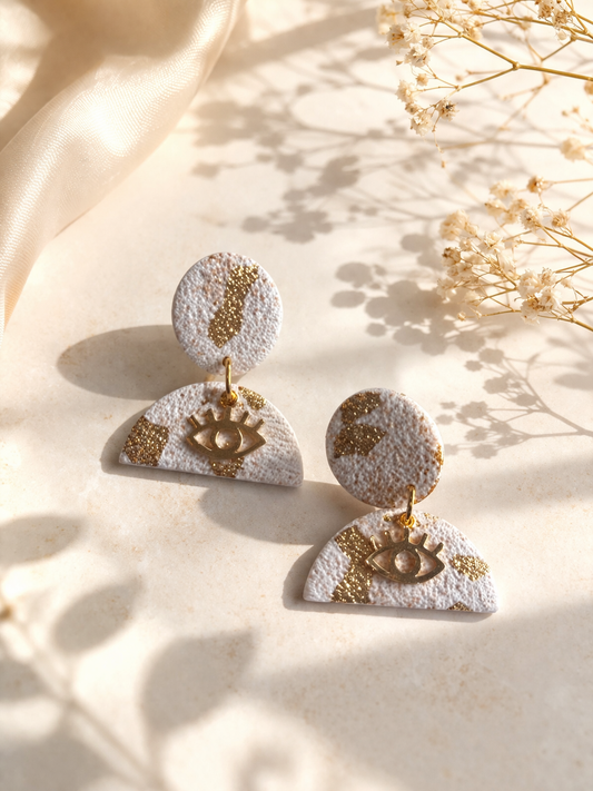 Boucles d’oreilles blanches et dorées légères Lumière divine Les Trésors de Cia, visibles avec détails élégants.