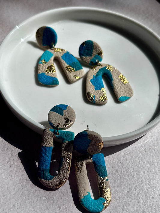 Boucles d’oreilles légères bleu et doré de la marque Les Trésors de Cia, avec design élégant et finition brillante.