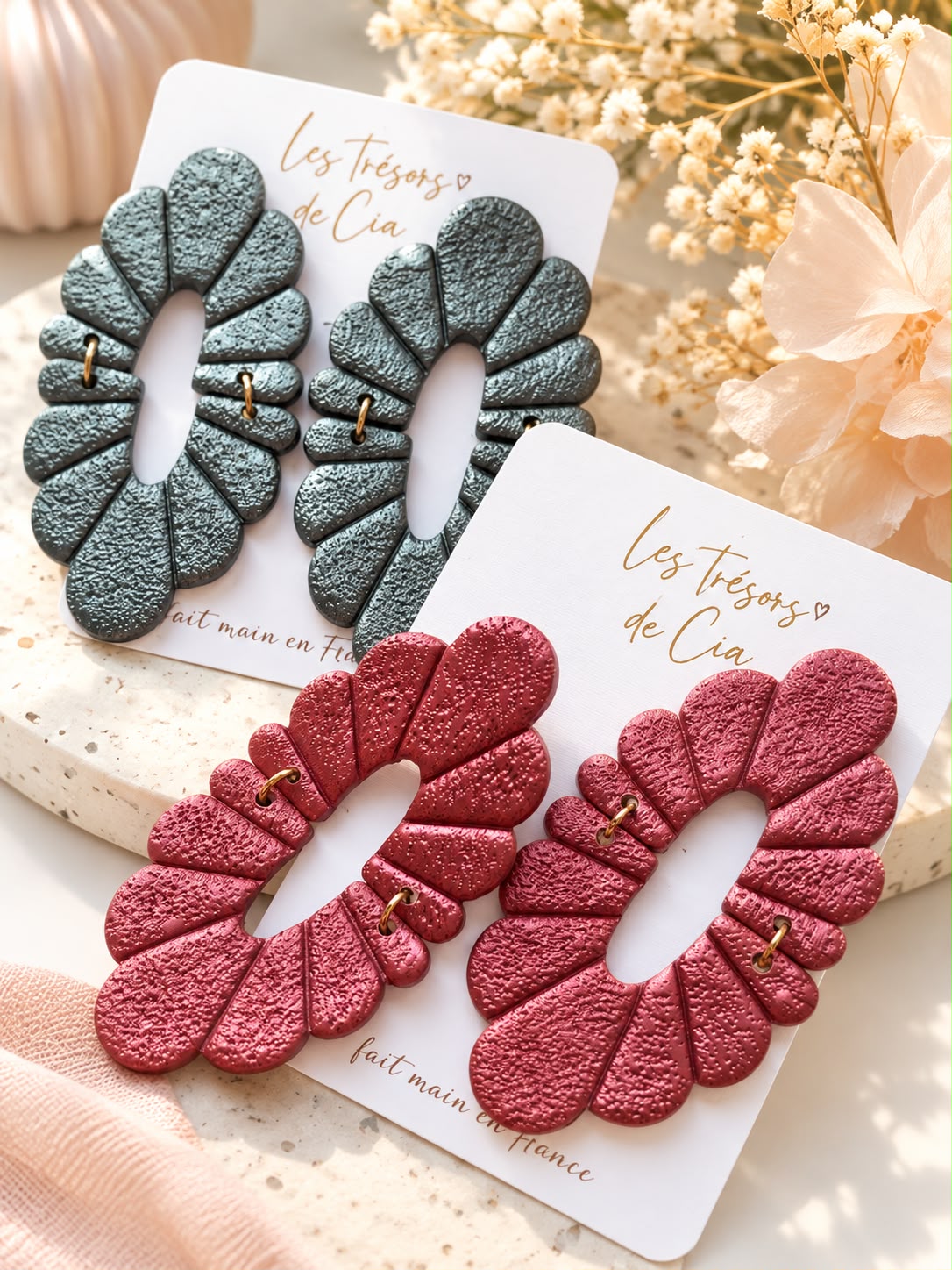 Deux paires de boucles d'oreilles Penelope en argile métallisée, anthracite et framboise, sur des cartes Les Trésors de Cia