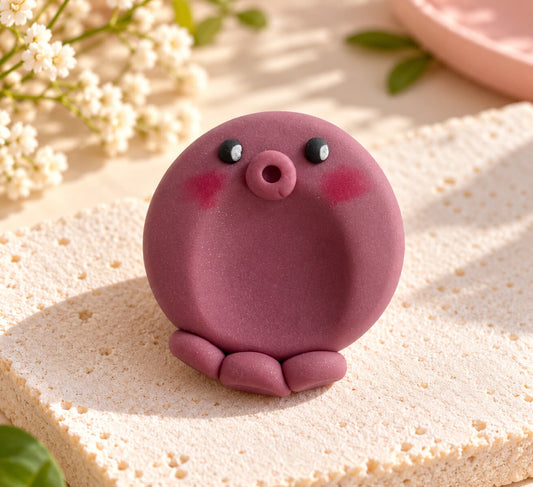 Pierre d'apaisement pieuvre kawaii en argile polymère violette, joues roses et trois tentacules