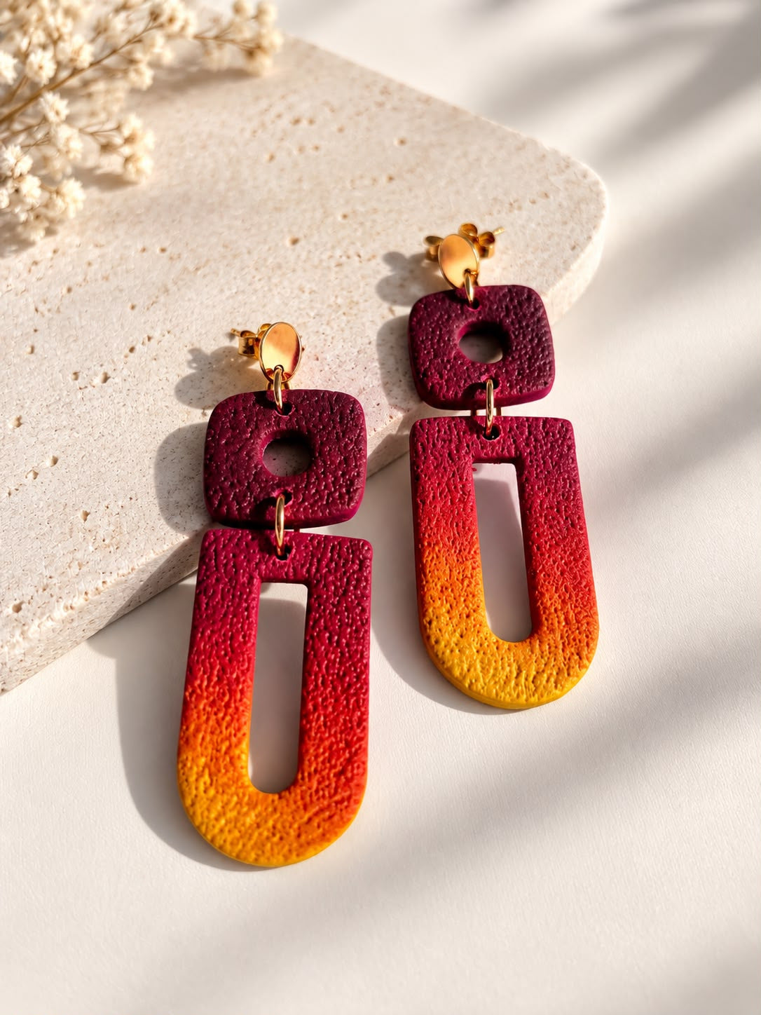 Boucles d'oreilles pendantes RAINBOW D'AUTOMNE en argile polymère, dégradé bordeaux, rouge et jaune safran sur arche évidée, puce dorée
