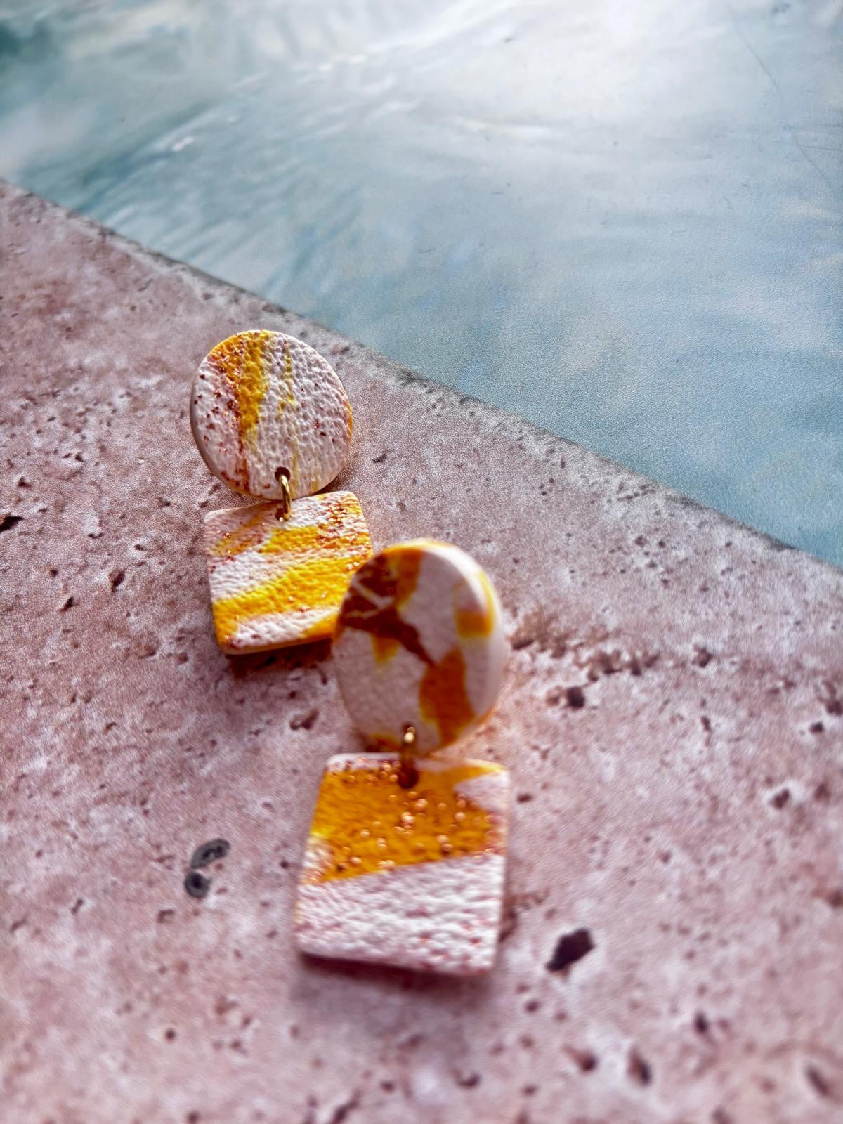 Boucles d'oreilles blanc rosé à bandes jaune vif et orange, surface granuleuse, puce ronde surmontant un carré aux angles arrondis