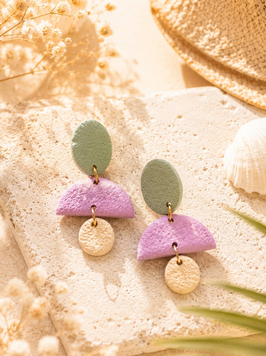 Boucles d'oreilles en argile polymère composées d'un disque ovale vert sauge, d'une demi-lune lilas et d'un petit disque beige sable, finition mate texturée