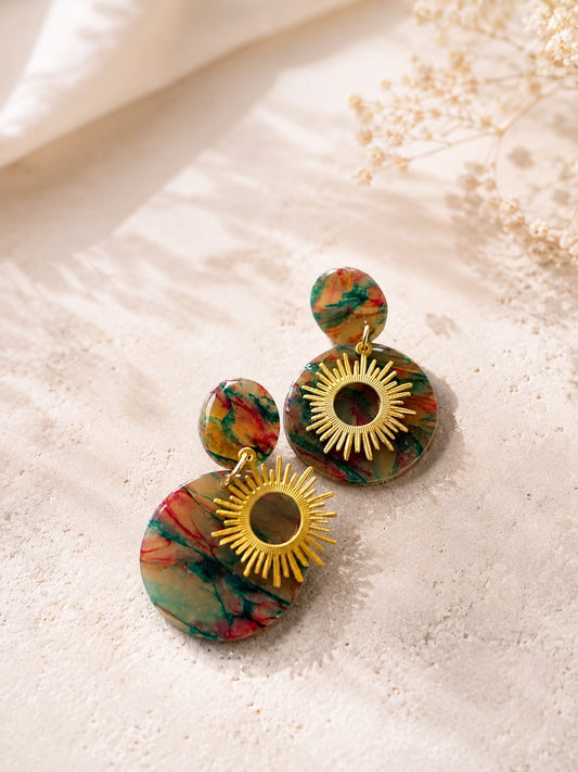 Paire de boucles d'oreilles disque marbré vert, rouge et ambre avec un soleil doré ajouré posé dessus